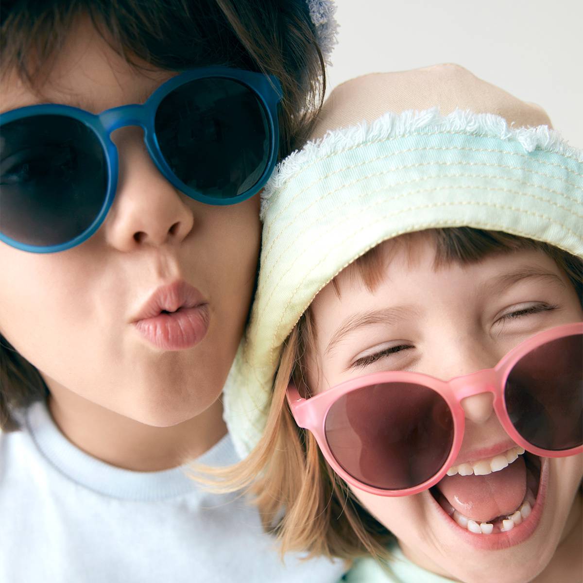 أطفال يرتدون نظارات شمسية وقبعات شمسية 